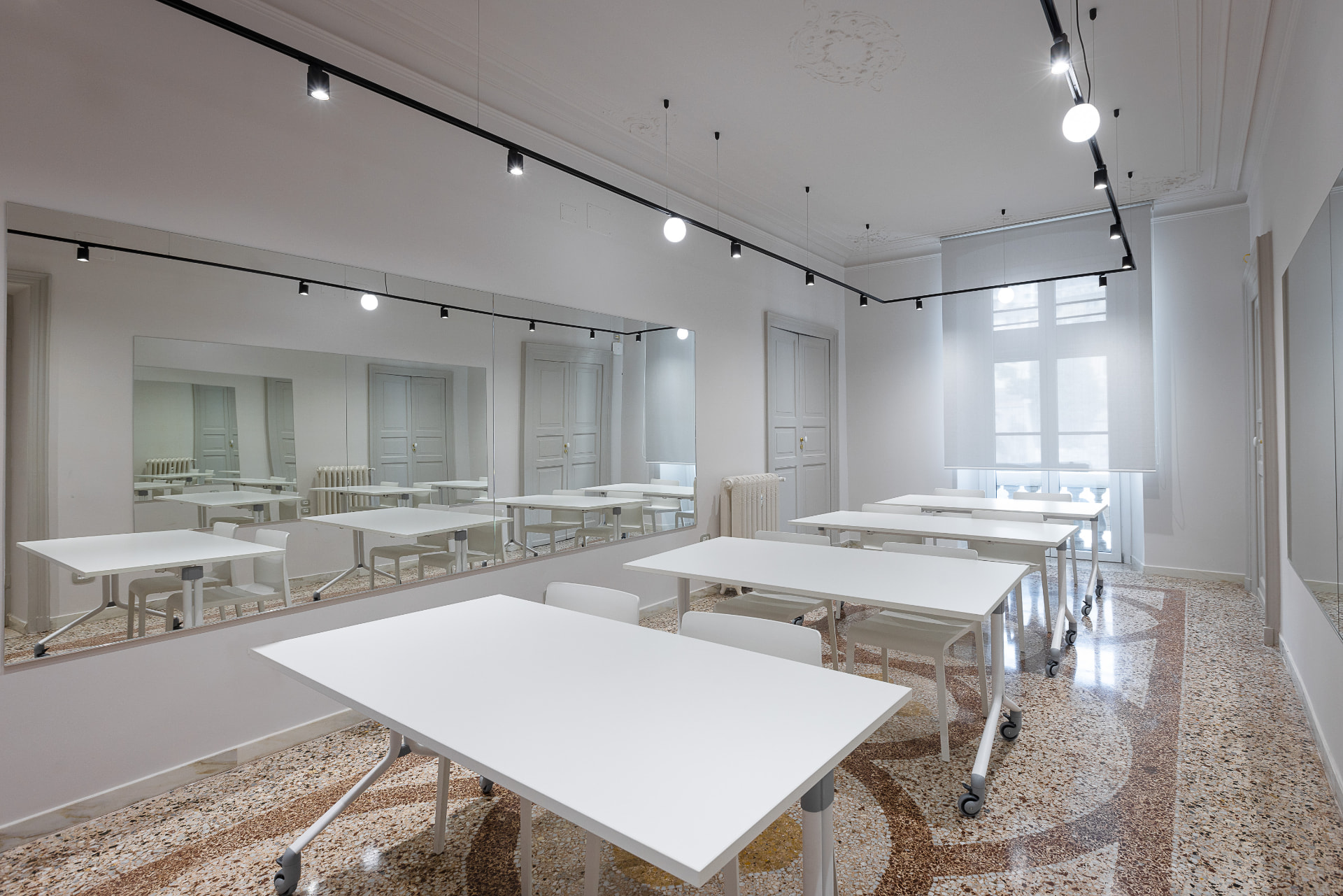 Aula didattica dell'Accademia Atelier CDC con postazioni di lavoro, specchi e luce naturale